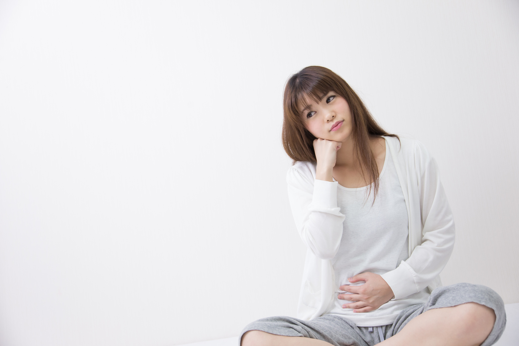 복부에 손을 얹고 불편함을 느끼는 여성