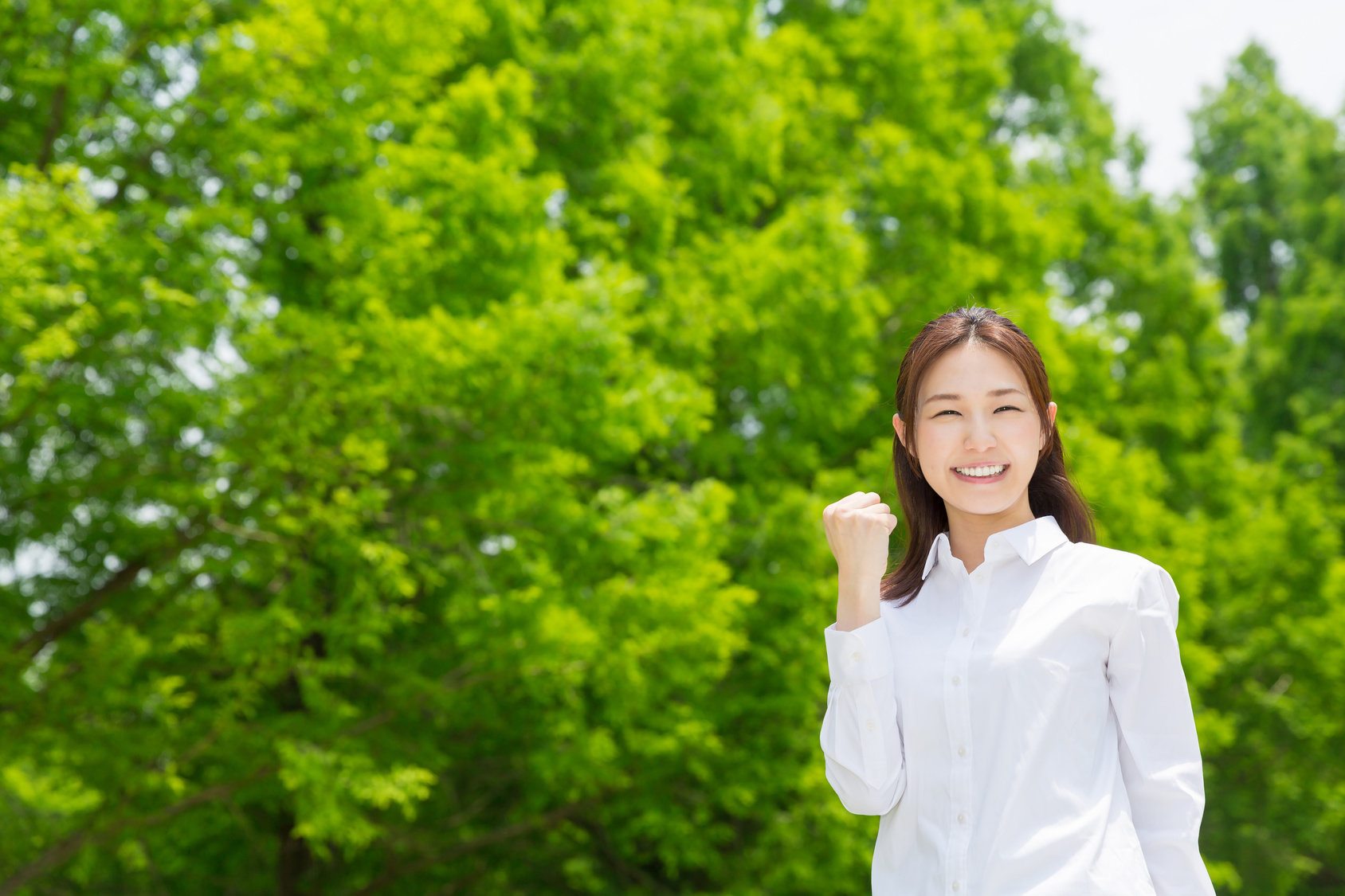 나무 곁에서 미소 짓는 여성